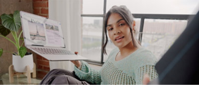 Eine Frau, die einen Laptop hält.