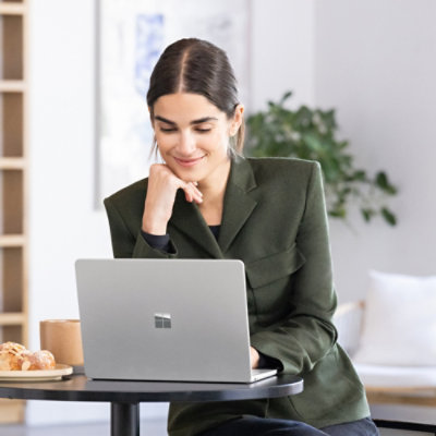 A person sitting at a table with a laptop in front of them.