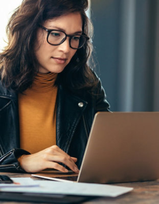 Eine Person mit Brille, die einen Laptop benutzt