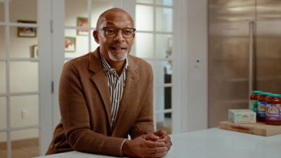 A man in a suite sitting at a table.