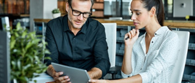 A man and woman looking at a laptop.
