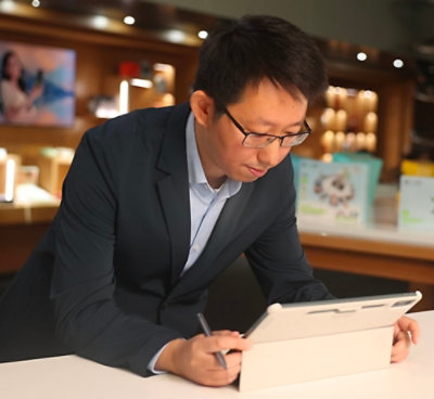 A man in a suit using a tablet.