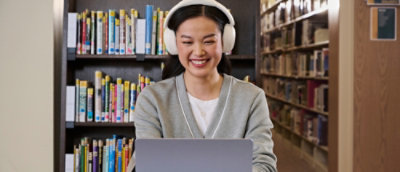 Eine Frau, die Kopfhörer trägt und ein Laptop verwendet