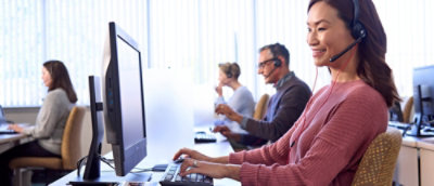 A group of people sitting at desks and working on computers.