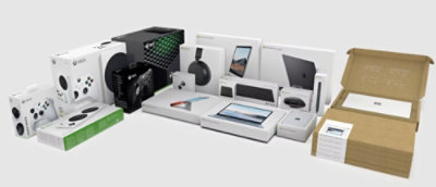 A group of electronic devices, including a white video game console, a green and white box with black circles, and a box with a white label.