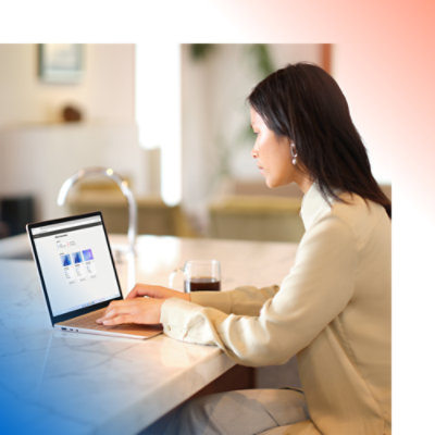 O femeie stă la o tejghea și utilizează un laptop.