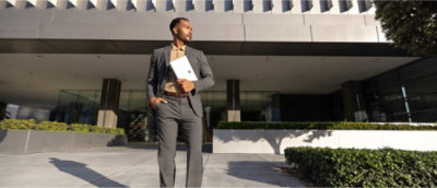 Un hombre con un traje sosteniendo una tableta.