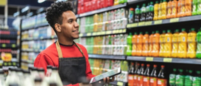 Ein Mann in einem roten Hemd und einer schwarzen Schürze, der ein Tablet hält