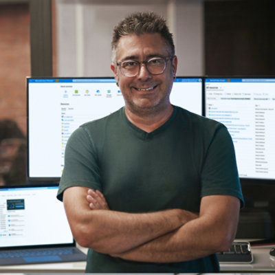 A person standing in front of multiple monitors.
