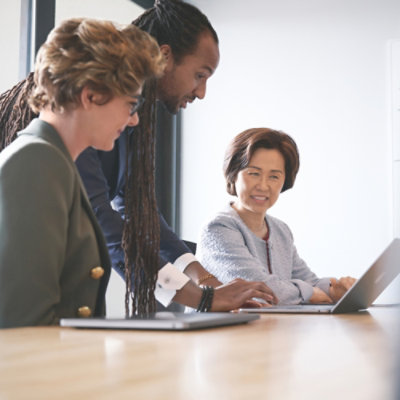 A group of people looking at a laptop.