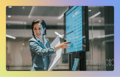 A woman explaining while pointing at the screen with some data