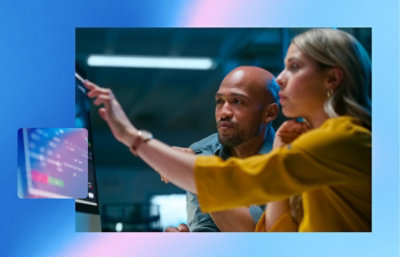  Two people reviewing data on a large screen, with one person pointing toward the display during a discussion.