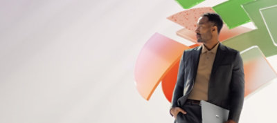 A person in a suit holds a sleek gray laptop, standing confidently against a background of colorful abstract shapes,.