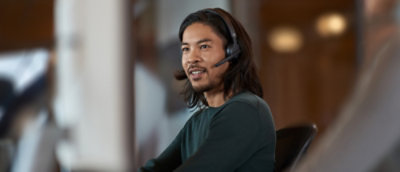 A man wearing a headset and a green shirt.
