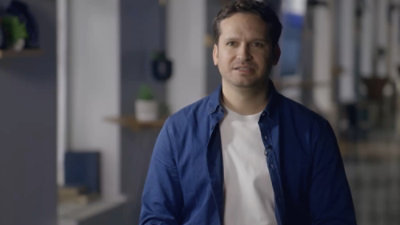 A man wearing a blue shirt with dark hair.