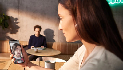 Kobieta robiąca zdjęcie innej osobie za pomocą telefonu.