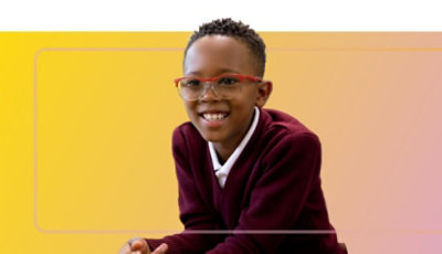 A smiling child wearing glasses.