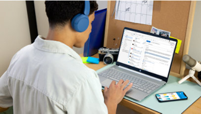 A college student uses Outlook on his laptop.