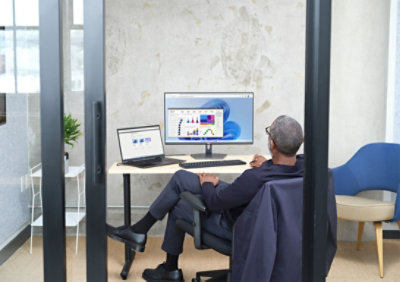 Eine Person, die an ihrem Schreibtisch an einem Windows 11-Computer arbeitet