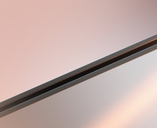 Zbliżenie narożnej krawędzi laptopa z lekkim rozbłyskiem