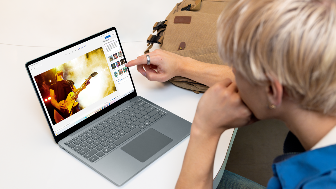 A young adult male inside editing images in Photos app on Surface Laptop