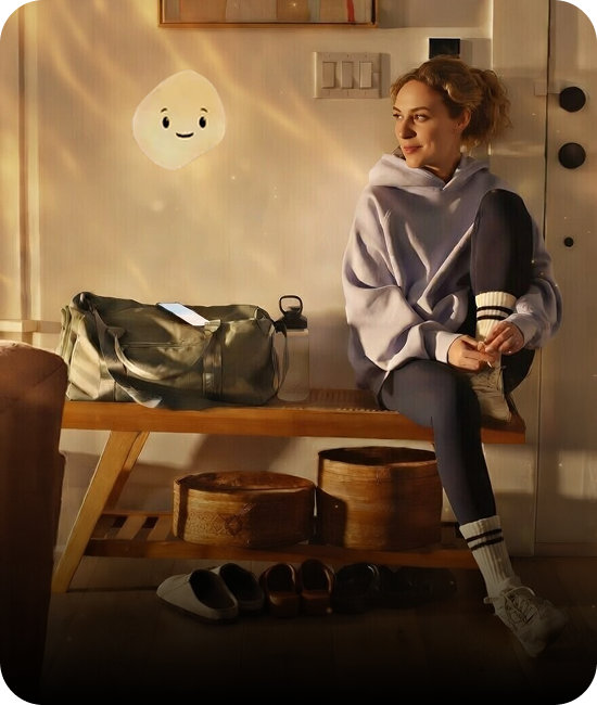 A woman sitting on a gymnasium bench in workout clothes with her gym bag with Mico floating nearby