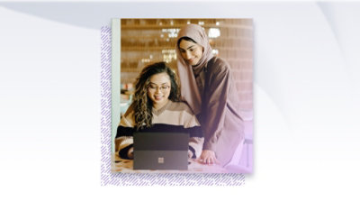 Two people working together and looking at a Surface device