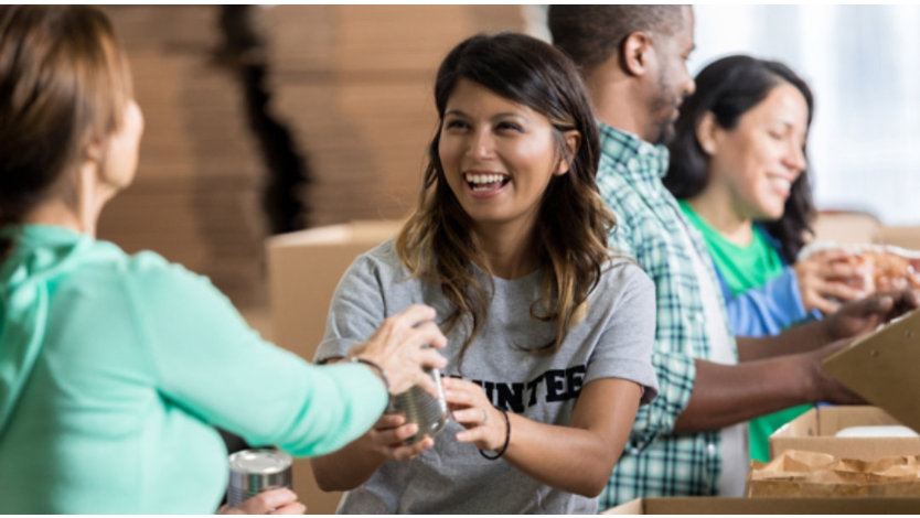Vrijwilligers pakken ingeblikt voedsel in dozen in