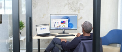 En mand, der sidder ved et skrivebord med en computer, der viser en graf.