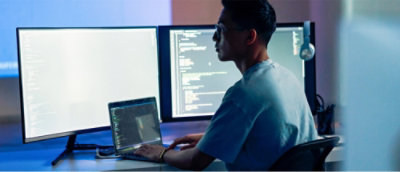 en mand, der sidder ved et skrivebord med en bærbar computer