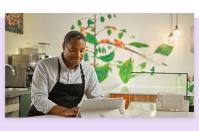 An employee wearing an apron using a tablet device.
