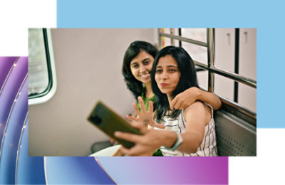A group of professionals in a conference room engaging in a video call with diverse colleagues displayed on a large screen.