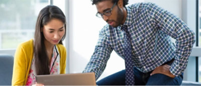 Dwie osoby patrzące na laptopa