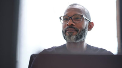 一个人看着桌面显示器的画面。