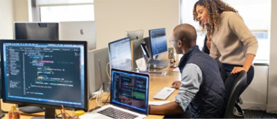 Dwie osoby pracujące na komputerach w biurze. 