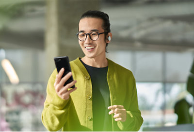 Personne portant des écouteurs et regardant un téléphone mobile