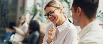 Gözlüklü bir kadın gülümsüyor.