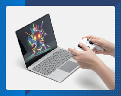 Osoba trzymająca joystick i pracująca na laptopie