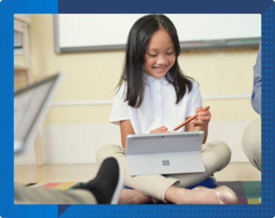 Uśmiechnięte dziecko siedzące po turecku na dywanie używające pióra cyfrowego z tabletem i spoglądające na ekran.