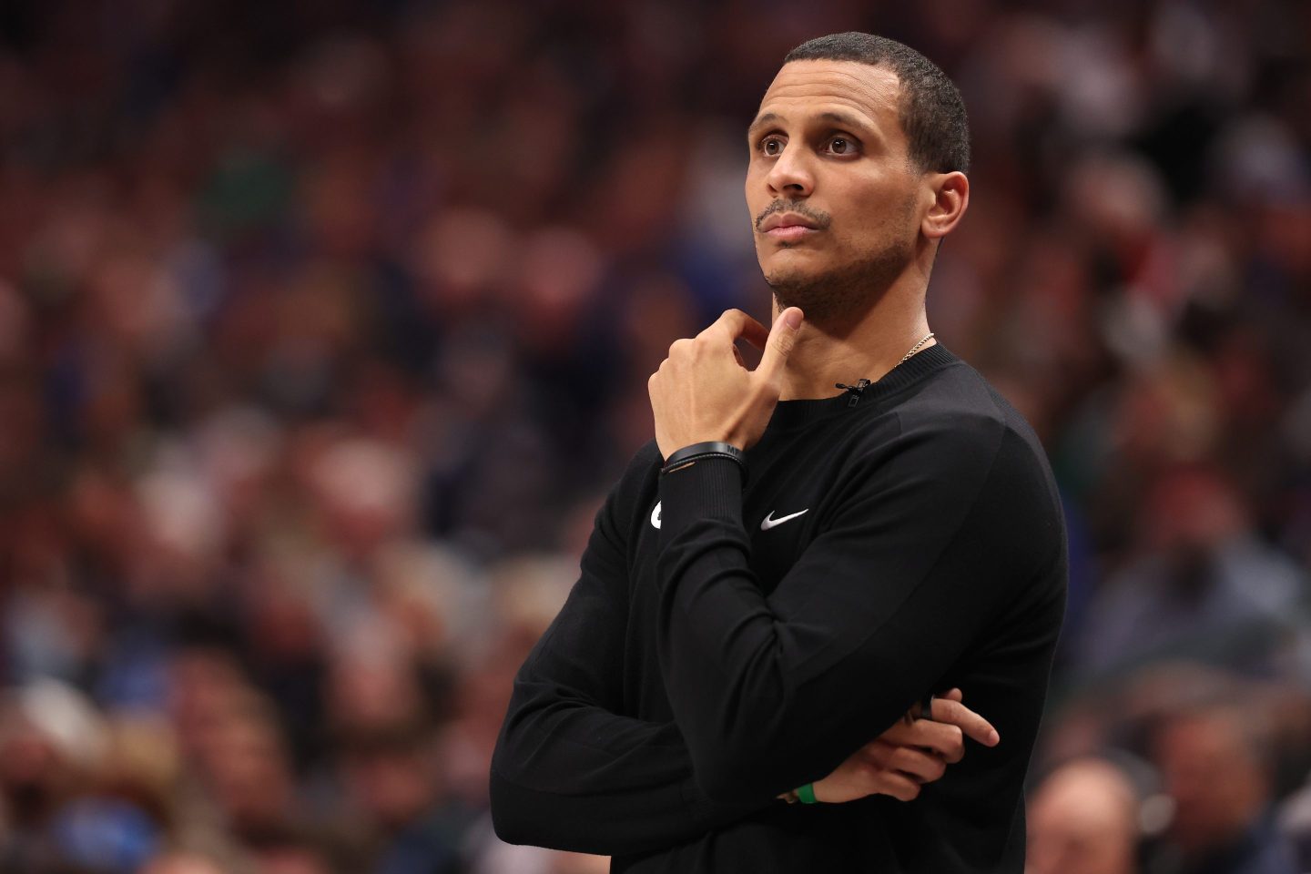 Boston Celtics head coach Joe Mazzulla stands on the court with his arms folded